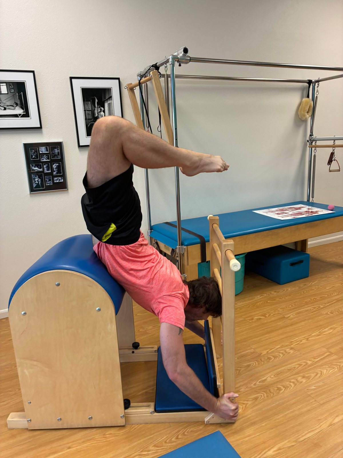 Seth Fowler holding an inverted Pilates pose on a ladder barrel